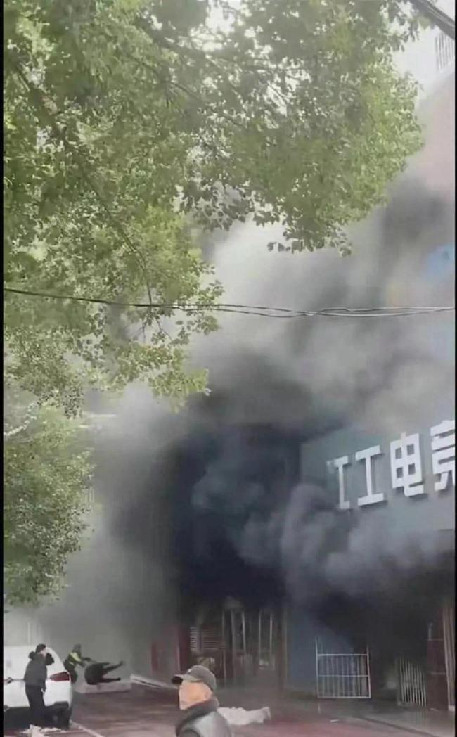 江西新余火灾致39死9伤 初步原因查明 消防人员在浓烟中进行拼命搜救，临街店铺遭受了巨大的损失